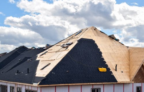 The process of installation of black roof shingles on new residential home