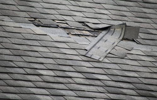 A badly damaged roof with missing shingles in need of repair